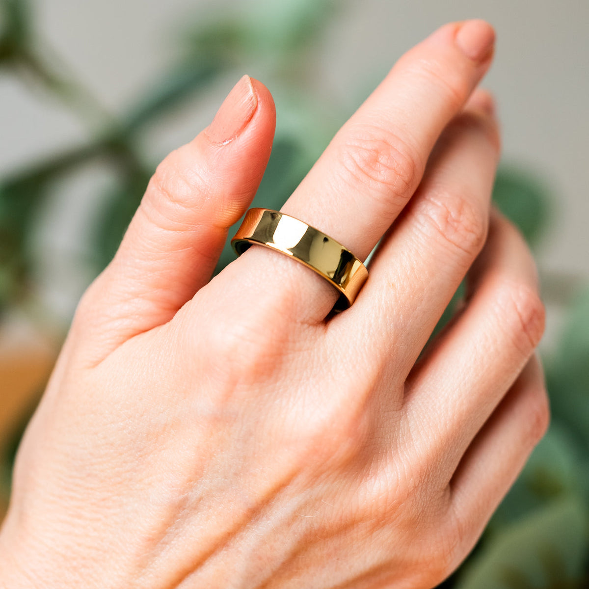 Kvindehånd med Luvo Ring II i guld på pegefingeren